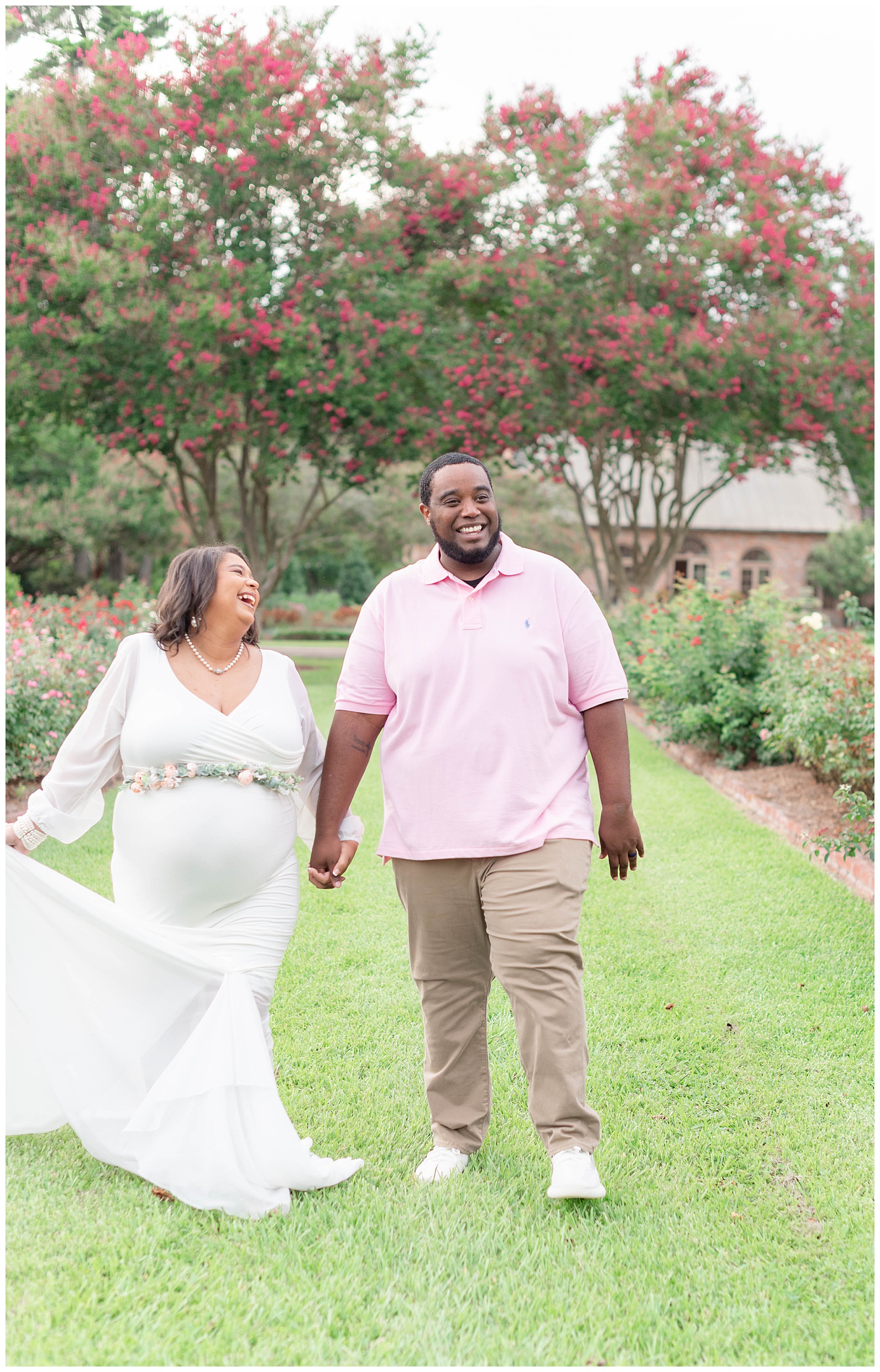 wife laughs with husband while walking in the rose garden at Burden Center