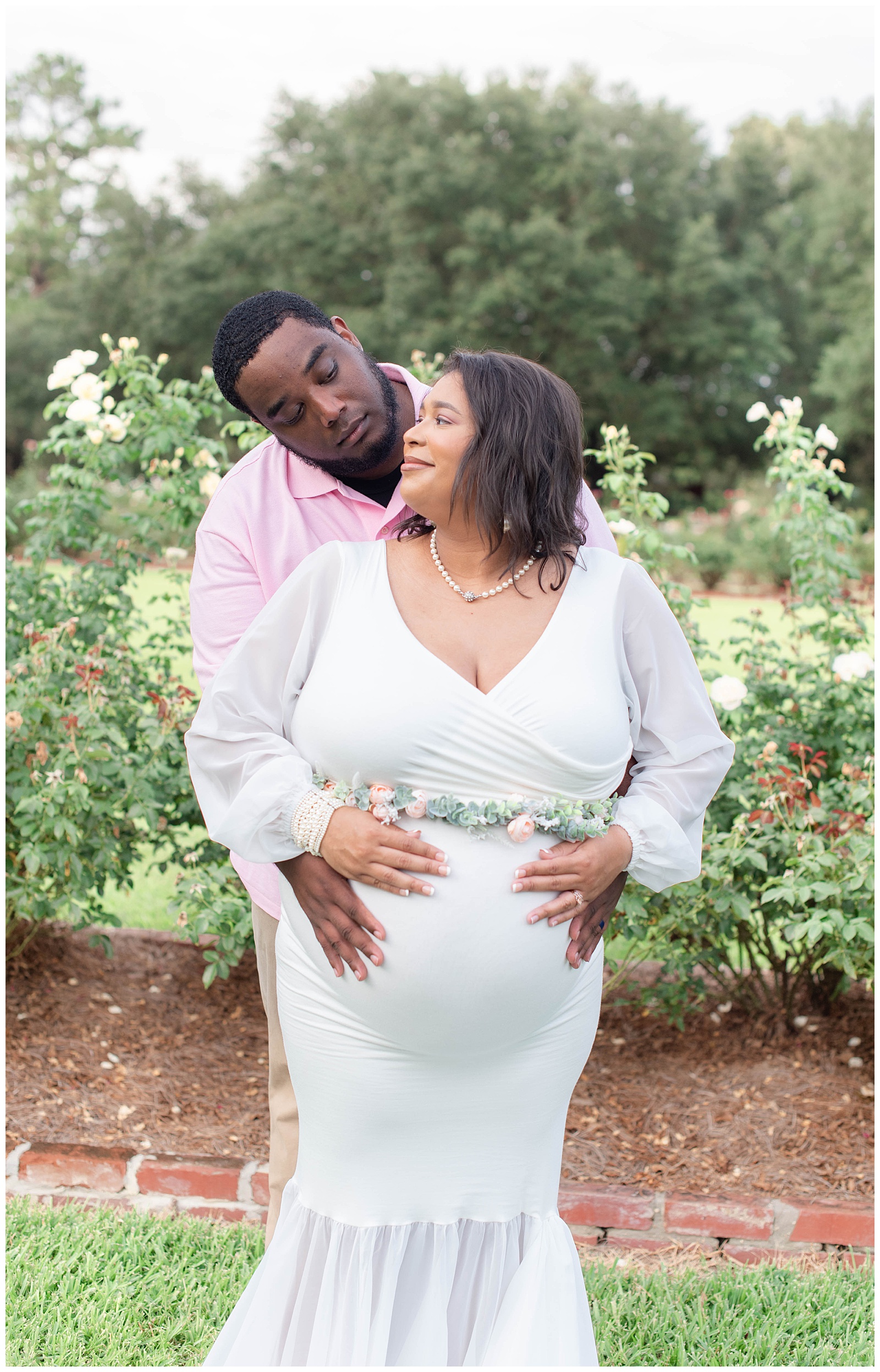 wife peeks up at husband in the rose garden at Burden Center