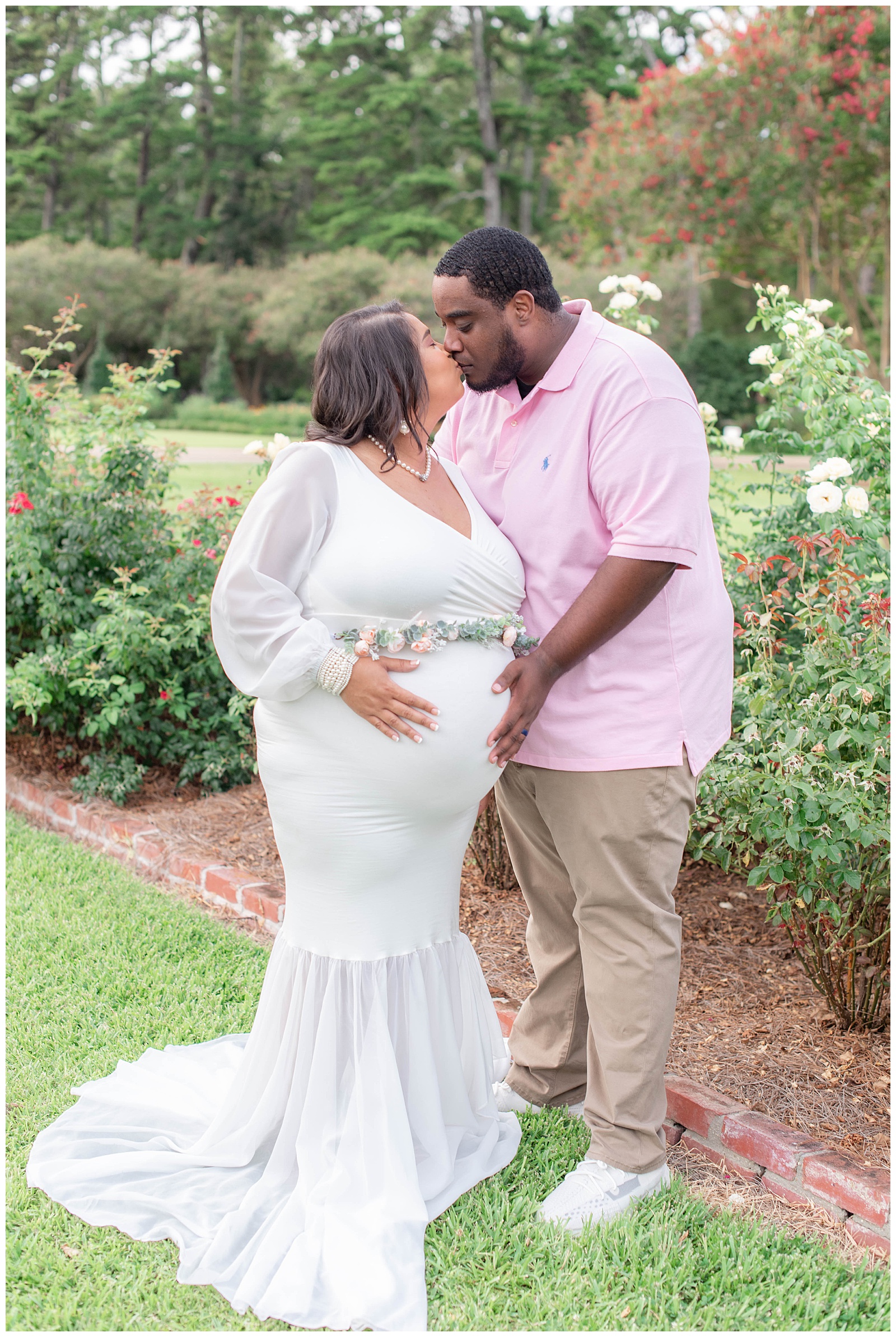 husband kisses wife in rose garden at Burden Center